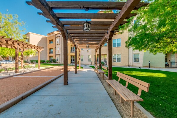 A covered outdoor area with benches and a pergola structure.