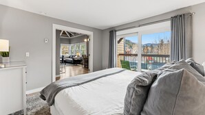 Un dormitorio con una cama grande, un escritorio y vistas al exterior.