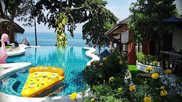 A pool area with a hot tub, lounge chairs, and a view of the ocean. - Clear View Resort (Koh Tao)