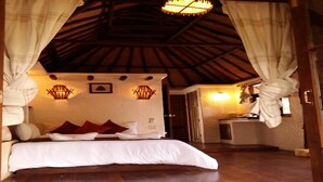 A bedroom with a wooden ceiling, a bed with white bedding, red pillows, and two wall-mounted lights. - Clear View Resort (Koh Tao)