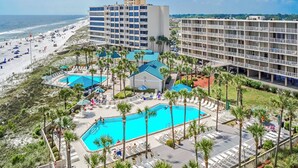 Ein Resort mit mehreren Schwimmbecken, einem Strand und verschiedenen Hotelgebäuden.