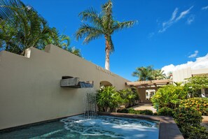 A pool with a waterfall, palm trees, and a building labeled "The Palms at Waier".