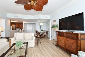 A living room with a sofa, coffee table, TV, and wooden cabinet.