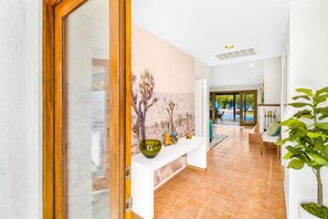 Welcome to our lobby, featuring a reception desk, a beautiful painting, and a view into the adjacent room.
