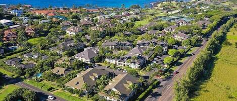 An aerial view of a residential area with houses, roads, and a coastline.