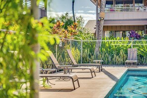 Zona de piscina con sillas de descanso y una alberca.