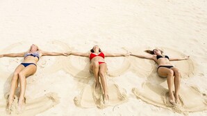 Three individuals lying on a sandy beach with their arms extended. - Luxury Condo, Ocean & Golf Course View, access (Herradura)