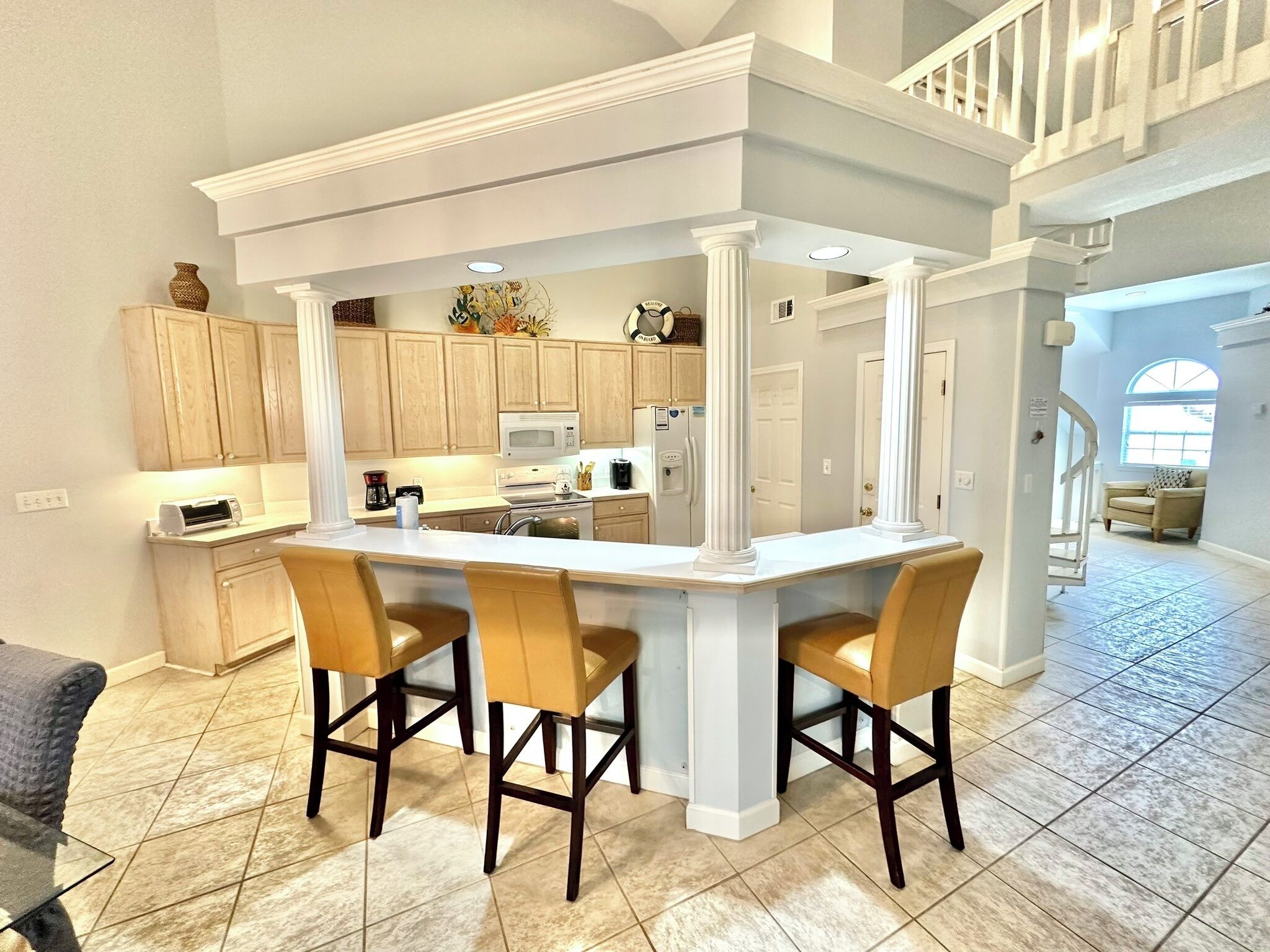 A spacious kitchen with a central island, wooden cabinets, and a modern design.
