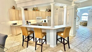 A spacious kitchen with a central island, wooden cabinets, and a modern design. - Villa close to beach Includes 6-Seat Golf Cart! 5257 TS (Miramar Beach)