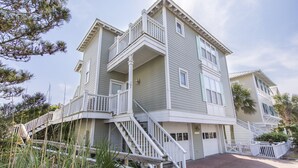 A multi-story building with a balcony on the second floor, a staircase leading to the entrance, and a small porch area. - Fabulous Gulf Front Home, Gated neighborhood, Double porches, Santa Rosa Beach (Santa Rosa Beach)