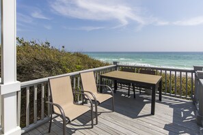 A wooden deck with a table and chairs overlooking the ocean. - Fabulous Gulf Front Home, Gated neighborhood, Double porches, Santa Rosa Beach (Santa Rosa Beach)