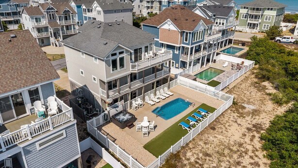 A beachfront residential area with multiple houses, a swimming pool, and a hot tub. - Only 70 Steps to beach access! Elevator! Heated Pool!  Pets, Pool Table, Hot tub (Corolla)