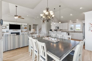 A spacious kitchen with a central island, white cabinetry, and a chandelier.