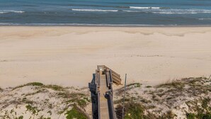 A beach with a wooden walkway leading to the water. - Only 70 Steps to beach access! Elevator! Heated Pool!  Pets, Pool Table, Hot tub (Corolla)