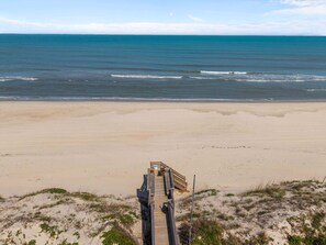 A beach with a wooden walkway leading to the water. - Only 70 Steps to beach access! Elevator! Heated Pool!  Pets, Pool Table, Hot tub (Corolla)