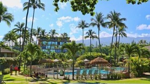 Un resort con piscina, palmeras y cielo despejado.