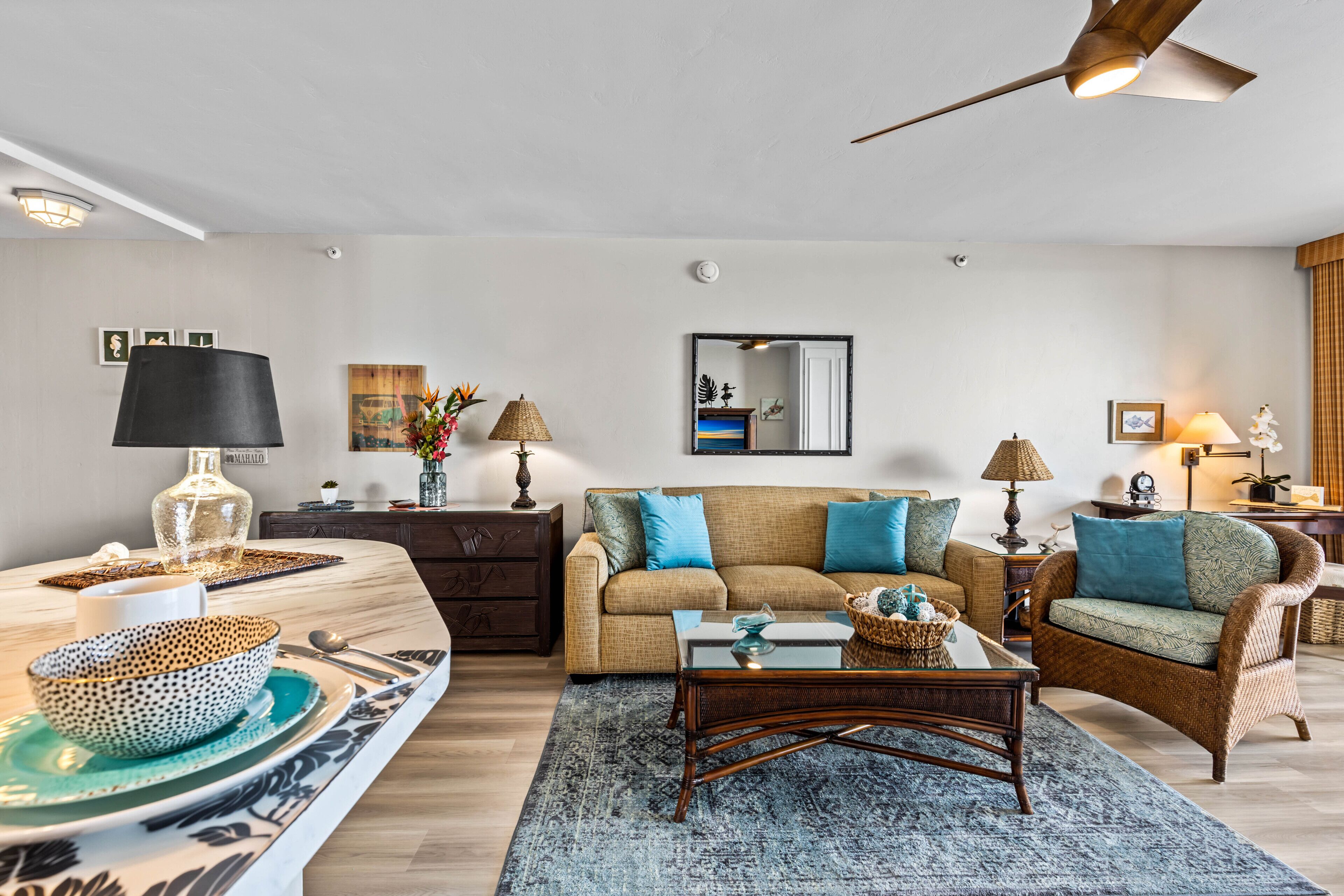 Un salon comprenant un canapé, deux fauteuils, une table basse et un coin repas avec une table et des chaises.
