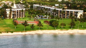 Un hôtel comprenant plusieurs étages, un court de tennis et un espace de plage.