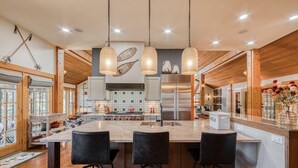 Una cocina amplia con una isla grande, detalles de madera y electrodomésticos modernos.