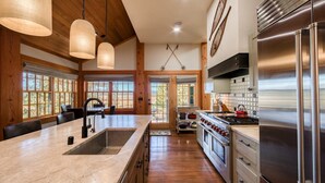 Una cocina amplia con una isla grande, electrodomésticos de acero inoxidable y detalles de madera.