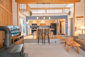 Une cuisine moderne avec des meubles en bois, un îlot central et des tabourets de bar.