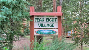 Señal de Peak Eight Village con un paisaje pintado.