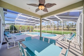 Relax by the pool in a tranquil outdoor space with lounge chairs and a table.