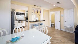 A modern kitchen with white cabinets, a black countertop, and a white dining table with chairs. - 356 Billfish🐟Beachside Townhome🐶Pet Friendly (Fort Walton Beach)