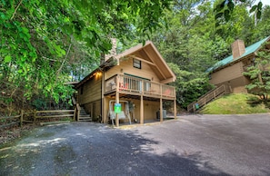 A lodge with a balcony, a covered porch, and a staircase leading to the upper level.