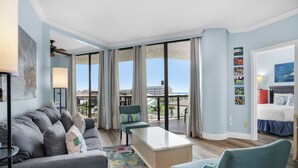 Una habitación de hotel moderna con balcón, un conjunto de sofá, una mesa de centro y una cama.
