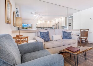 Ein modernes Wohnzimmer mit einer Couch, einem Couchtisch und einem Essbereich mit einem Stuhl.