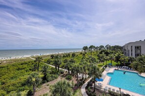 Relax by the pool surrounded by lush greenery and enjoy stunning views of the beach.