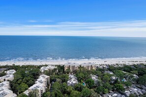 A coastal view with a beach, ocean, and residential buildings. - Spectacular Direct Atlantic Ocean Views Bikes & Beach Gear included (Hilton Head Island)