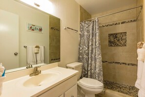 A bathroom with a sink, toilet, and shower.