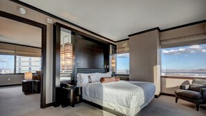 Ein modernes Hotelzimmer mit einem großen Bett, einem Schreibtisch und Blick auf die Stadtlandschaft.