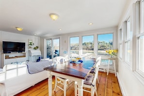 Enjoy meals at the dining table surrounded by comfortable chairs, with a flat-screen TV and kitchenette nearby, and take in the view from the large windows.