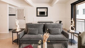 A modern living room with a grey sofa, a glass coffee table, and a vase with dried flowers. - Central Aspen Condo - Prime Price and Location (Aspen)