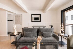 A modern living room with a grey sofa, a glass coffee table, and a vase with dried flowers. - Central Aspen Condo - Prime Price and Location (Aspen)