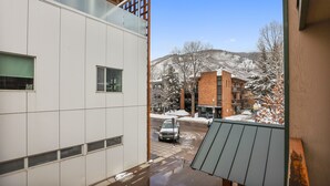A modern building with large windows and a view of a snowy mountain. - Central Aspen Condo - Prime Price and Location (Aspen)