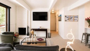 A modern living room with a fireplace, a flat-screen TV, and a seating area with a coffee table. - Central Aspen Condo - Prime Price and Location (Aspen)