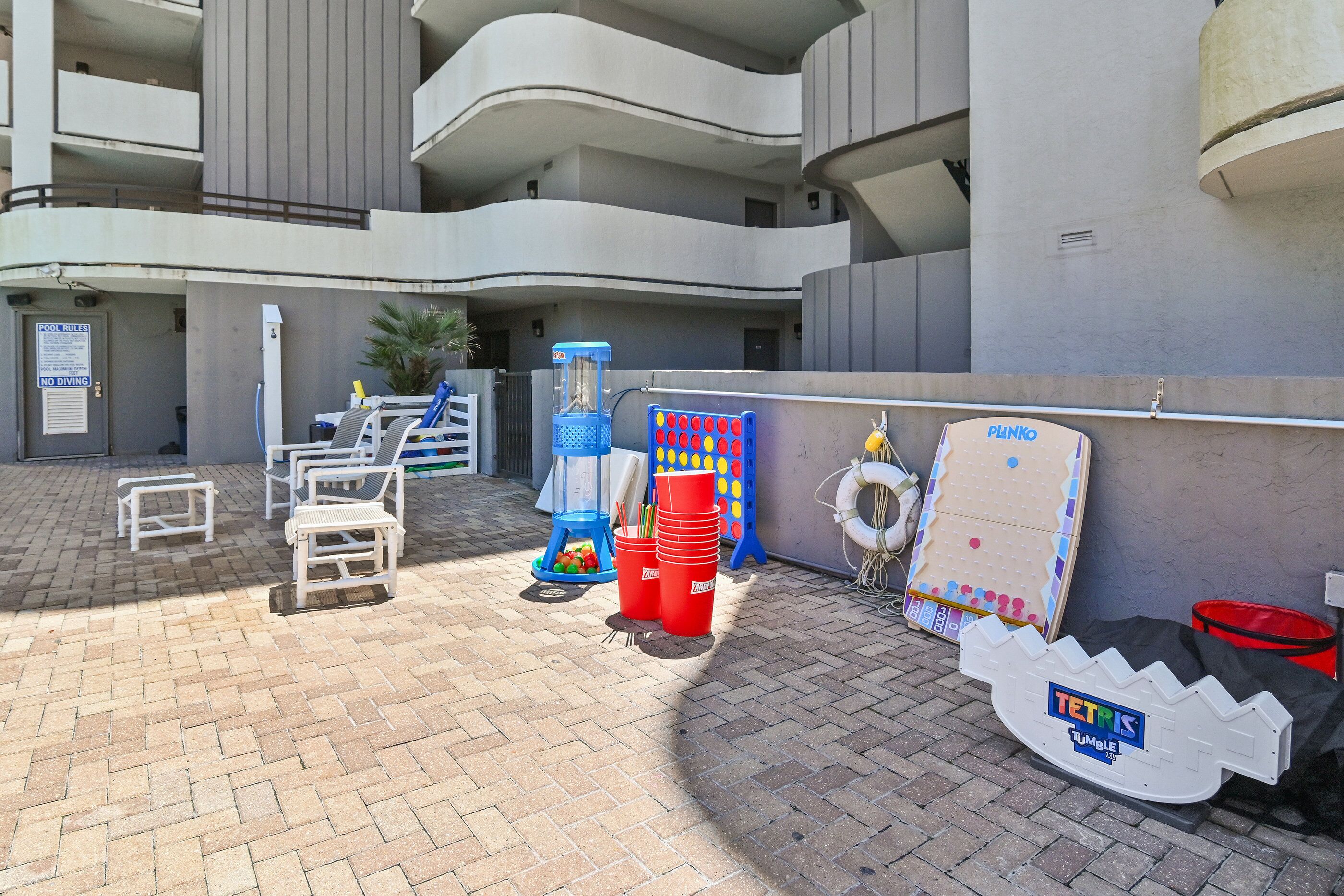 Un patio con mobiliario exterior, una zona de juegos infantiles y un edificio con balcones.