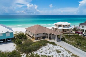 A beachfront property with multiple buildings, a sandy beach, and the ocean.