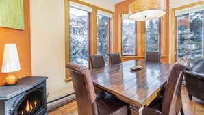 A dining room with a large wooden table, six chairs, and a fireplace. - Pet Friendly 2-bedroom, 2-bathroom condo, Manitou #101 and those views! (Telluride)