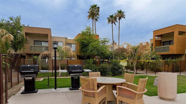 An outdoor patio with wicker furniture, two barbecue grills, and a large planter. - Endless Summer Modern 2 Bedroom Condo/ Community Pool/ Jacuzzi/ Scottsdale (Scottsdale)