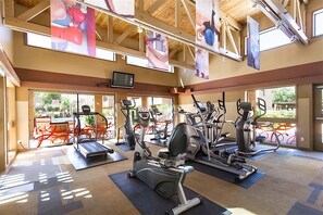 A gym with various exercise machines, large windows, and a high ceiling. - Endless Summer Modern 2 Bedroom Condo/ Community Pool/ Jacuzzi/ Scottsdale (Scottsdale)