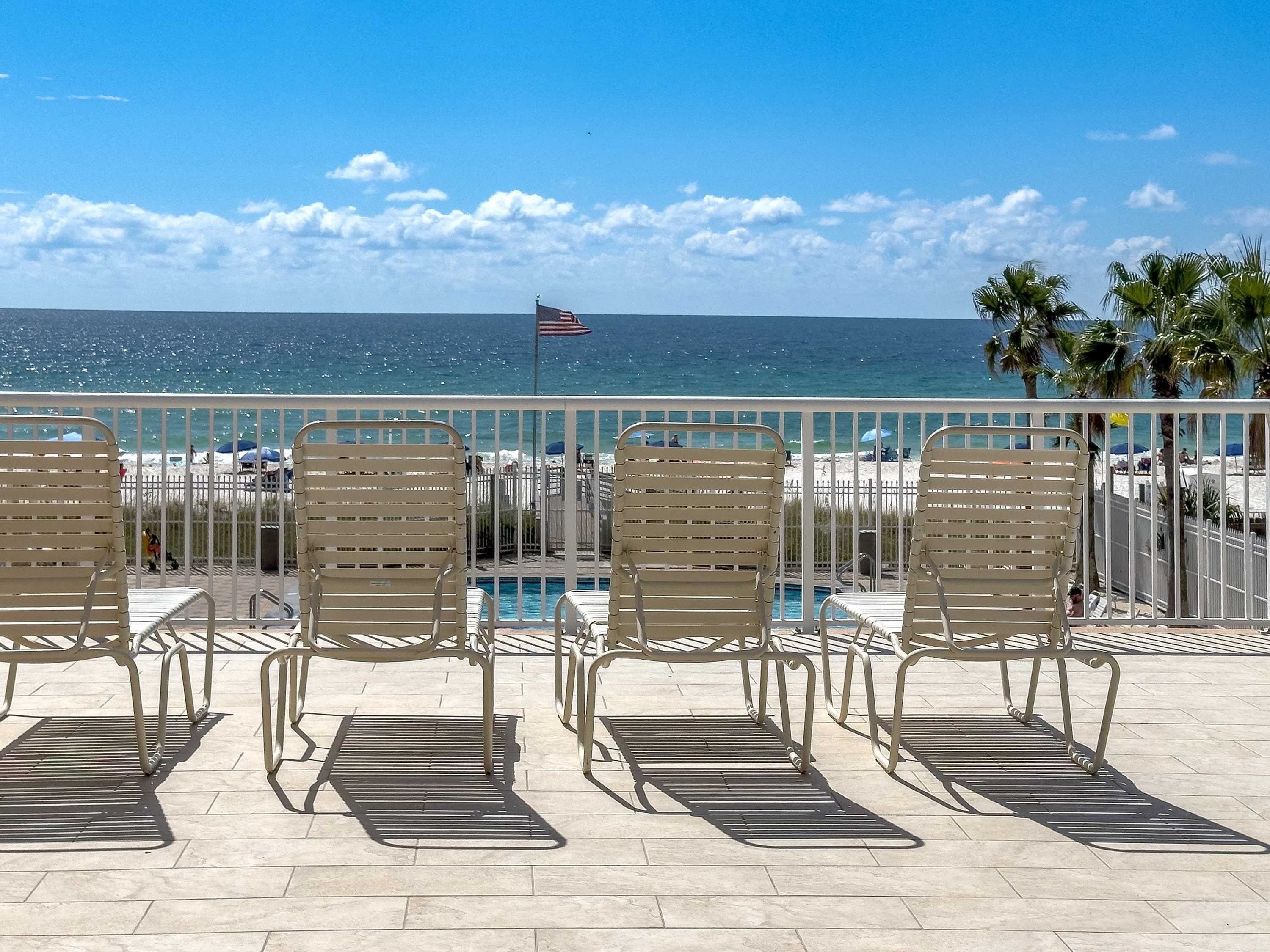 Un espace aménagé au bord de la piscine, avec des chaises longues et une vue sur l’océan.