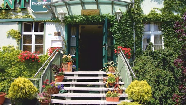 A building with a green facade, a sign reading "Frankfurter," and a staircase leading to the entrance. - Hotel Zur Alten Oder Frankfurt (Frankfurt an der Oder)