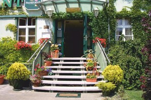 A building with a green facade, a sign reading "Frankfurter," and a staircase leading to the entrance. - Hotel Zur Alten Oder Frankfurt (Frankfurt an der Oder)