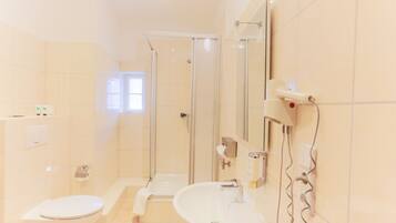 Un baño moderno con inodoro, lavamanos y ducha.