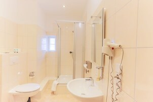 Un baño moderno con inodoro, lavamanos y ducha.